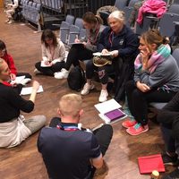 A group of people sat on the floor in discussion