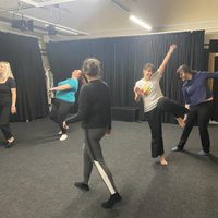 5 d ancers in a studio with a black floor and black walls