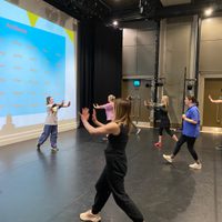 Dancers with arms outstretched moving on stage in different directions