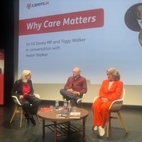 Three people sat around a table on stage