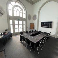 Wide angled photo of the whole meeting room with tables and catering arranged