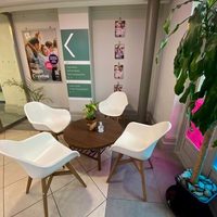 A seating area with a coffee table and 4 white chairs in the foyer area at Pavilion Dance