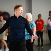 Dance teacher with pupils behind him