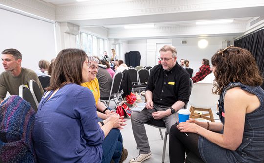 Three conference delegates sat in a dance studio