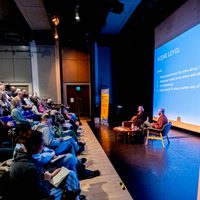 Audience watching two speakers on a stage
