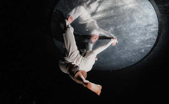 Ghostly dancers upside down on a moon like orb
