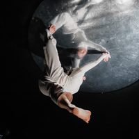 Ghostly dancers upside down on a moon like orb