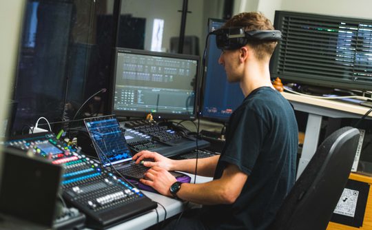 Stage Technician working a lighting desk